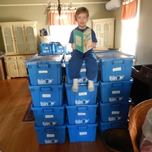 child sitting on moving bins